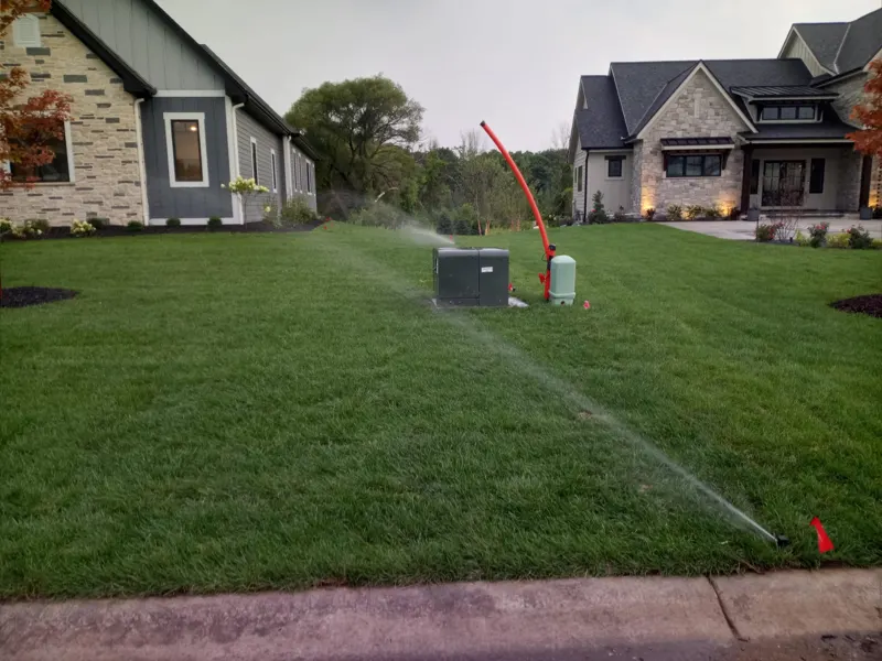 New sprinkler system watering the lawn of a newly built home