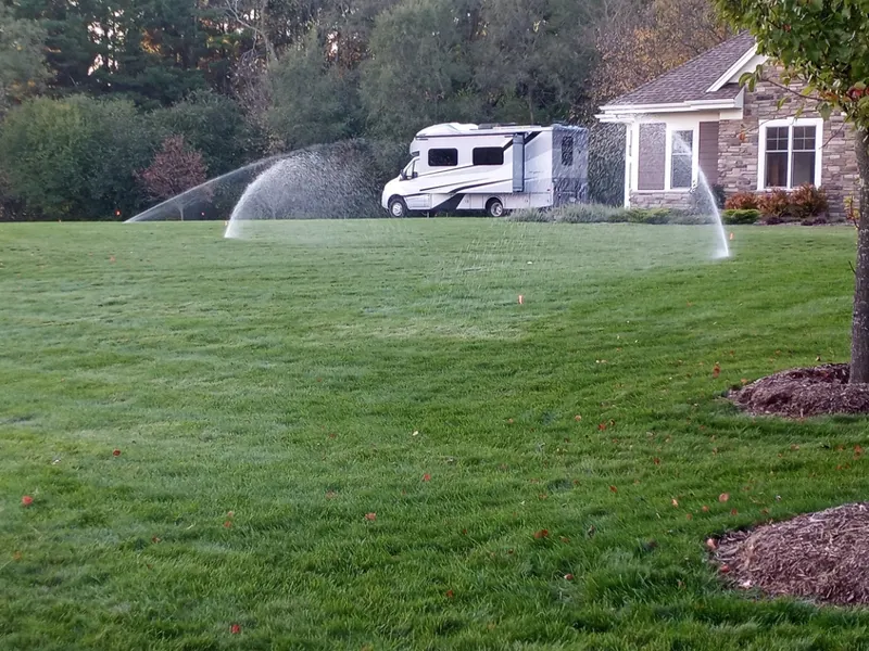 Rotor sprinklers watering a large residential lawn